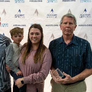 Michelle Thompson's family poses for a picture with her posthumous award for giving 25 years to Academy District 20.